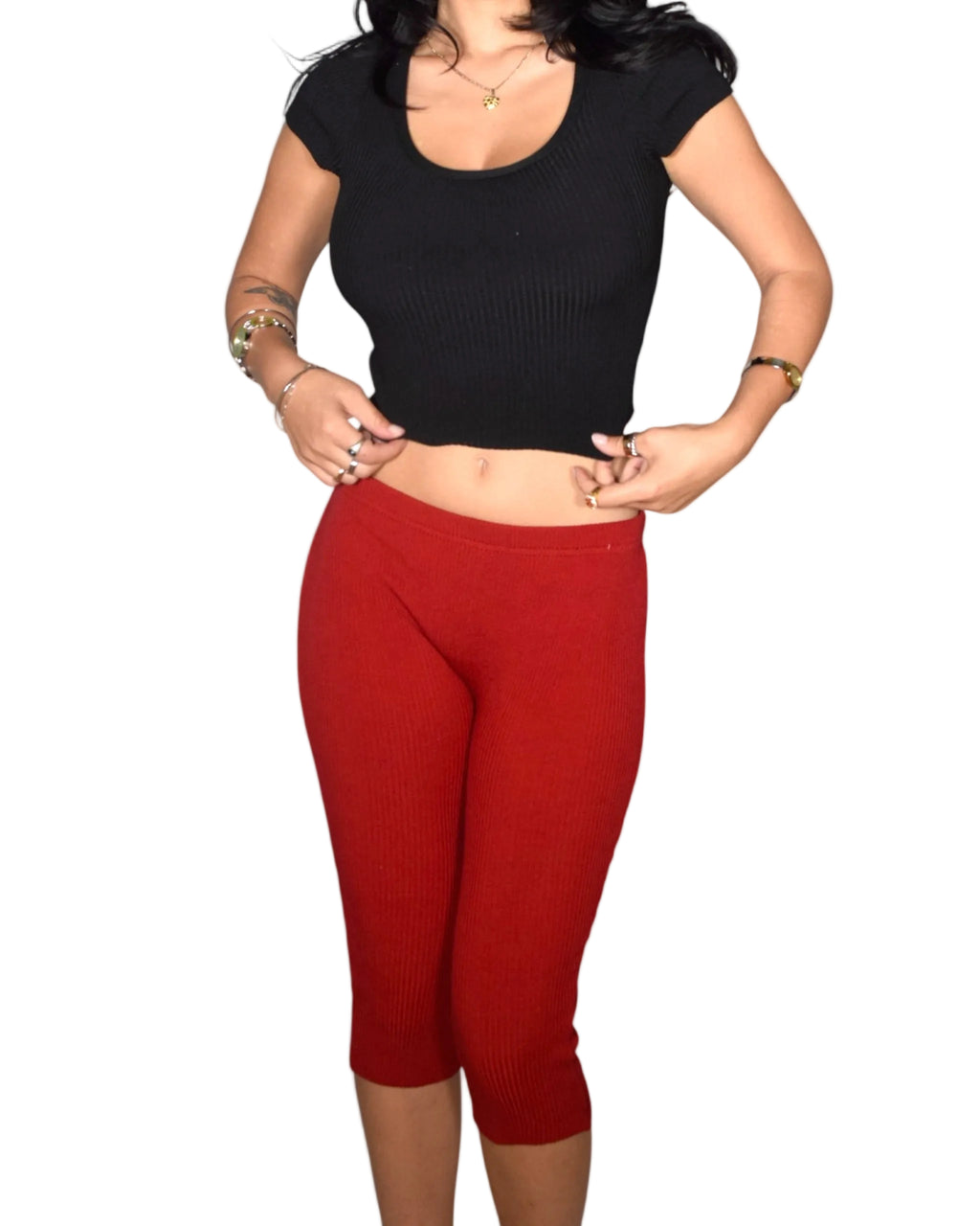 Person wearing a black crop top and red leggings on a white background