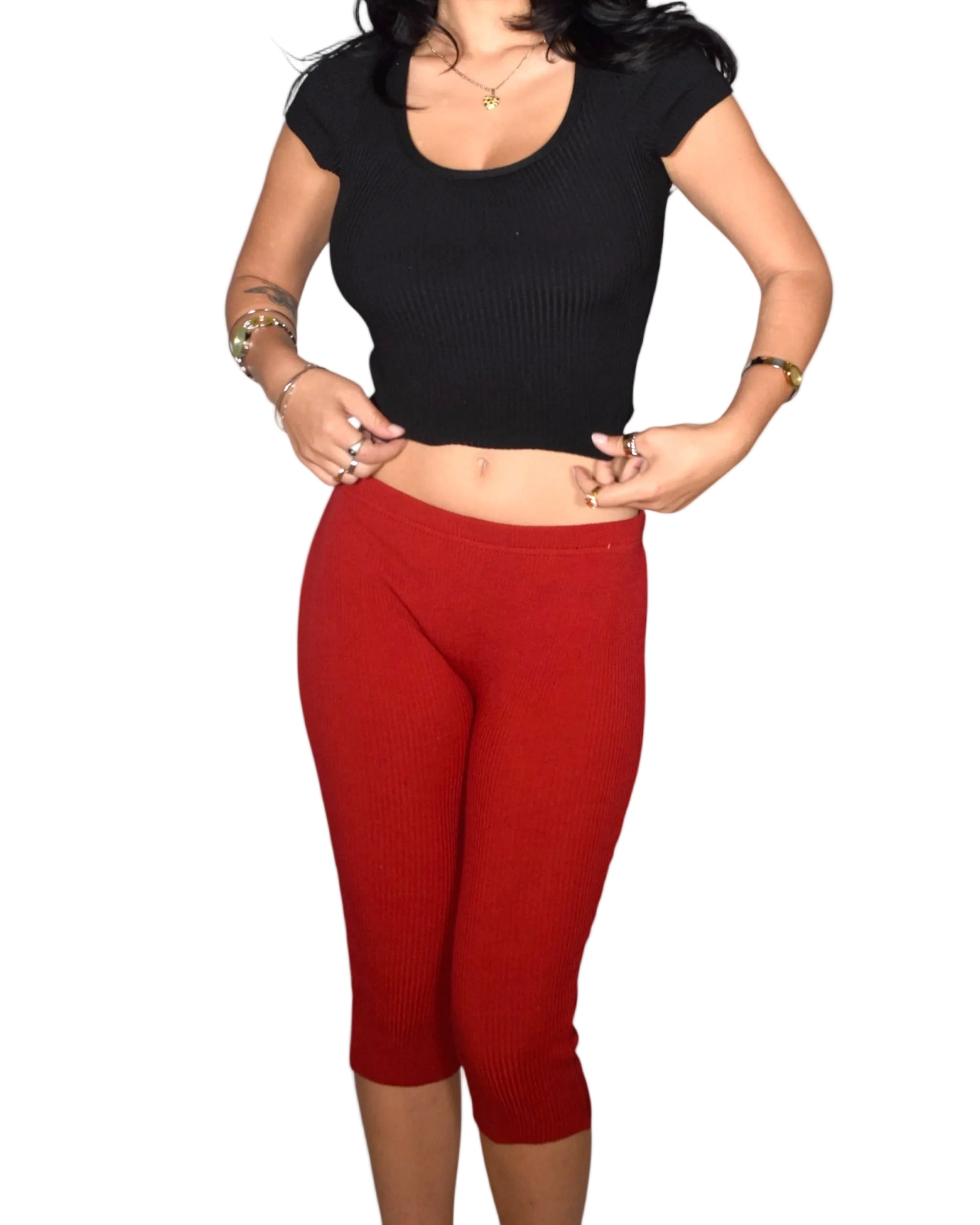 Person wearing a black crop top and red leggings on a white background