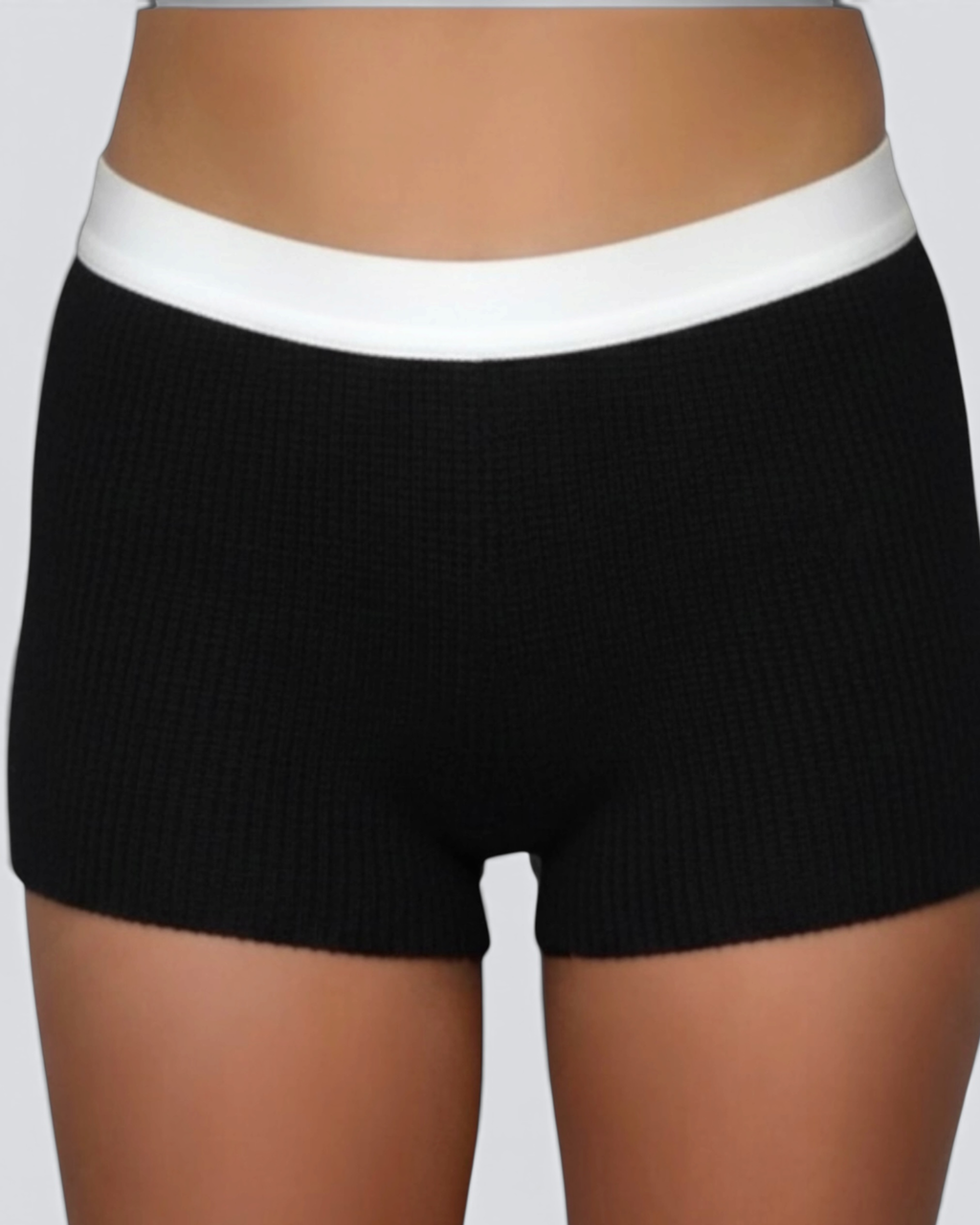 Black ribbed shorts with a white waistband on a neutral background