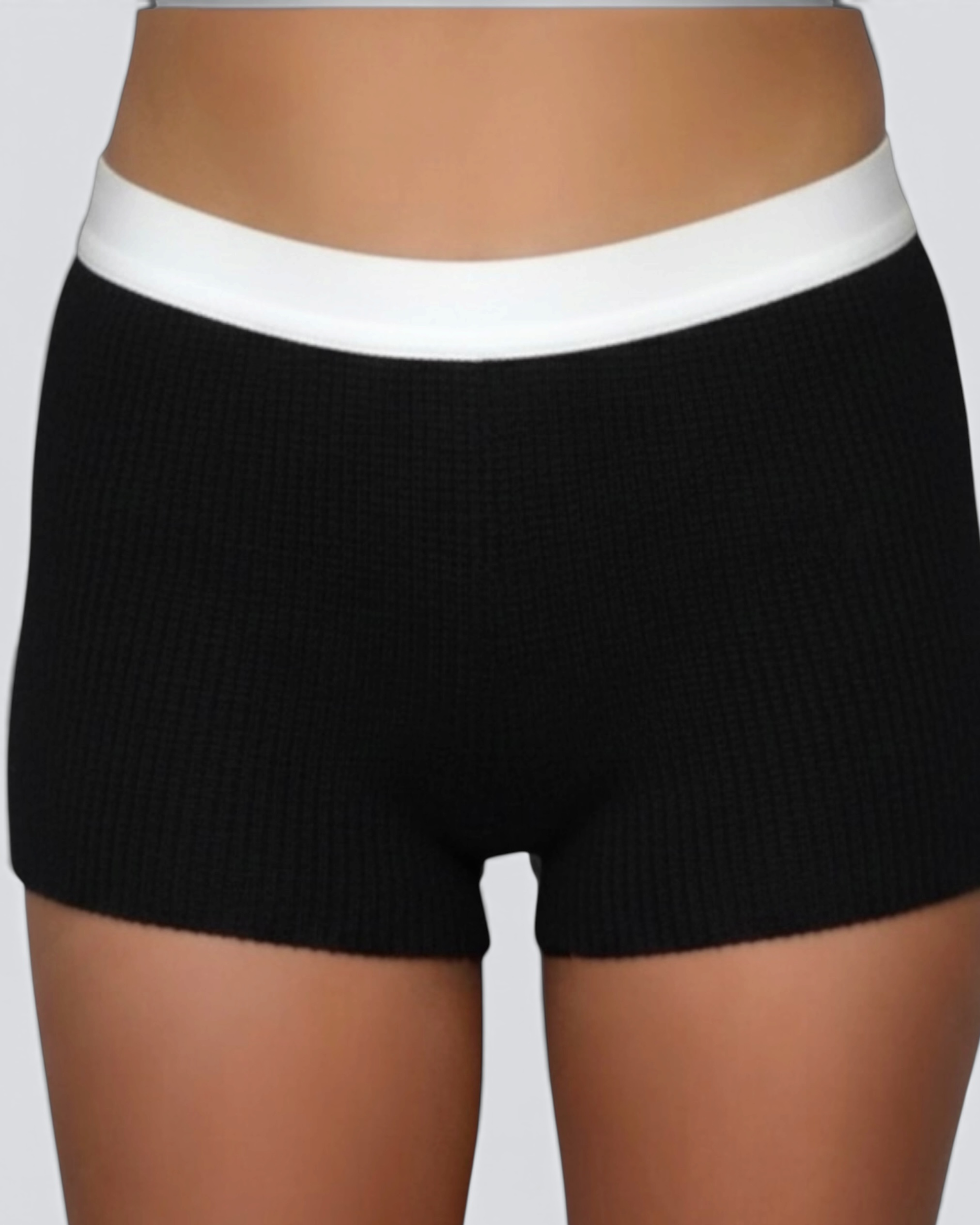 Black ribbed shorts with a white waistband on a neutral background