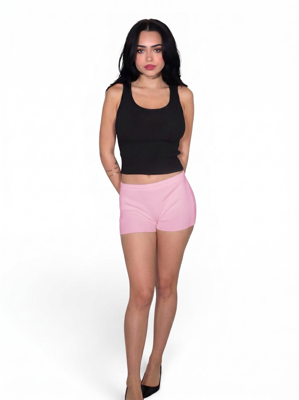 Woman wearing black rib knit tank and pink hot pants by TKHLA 