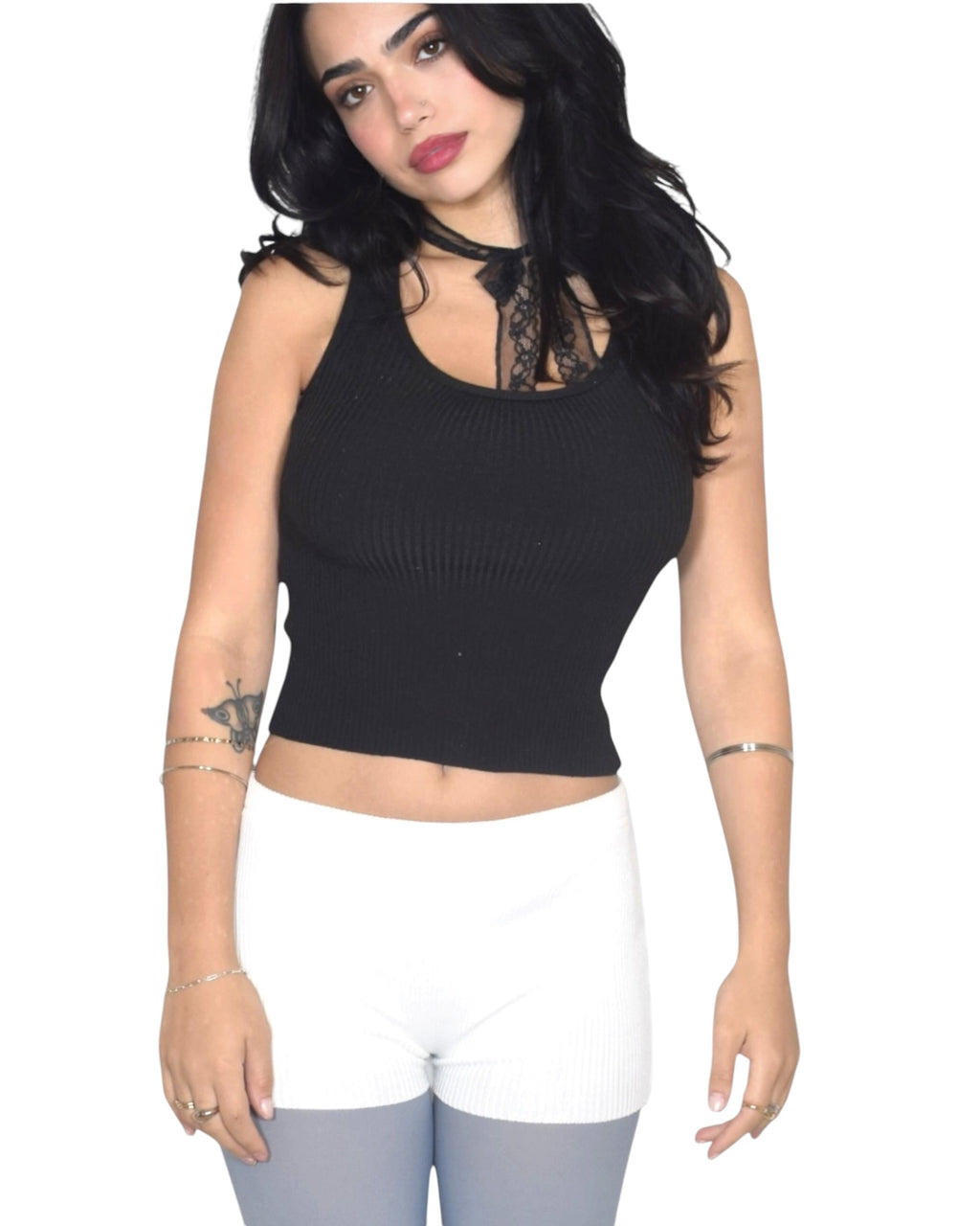 Woman wearing a black sleeveless top with lace details on a white background