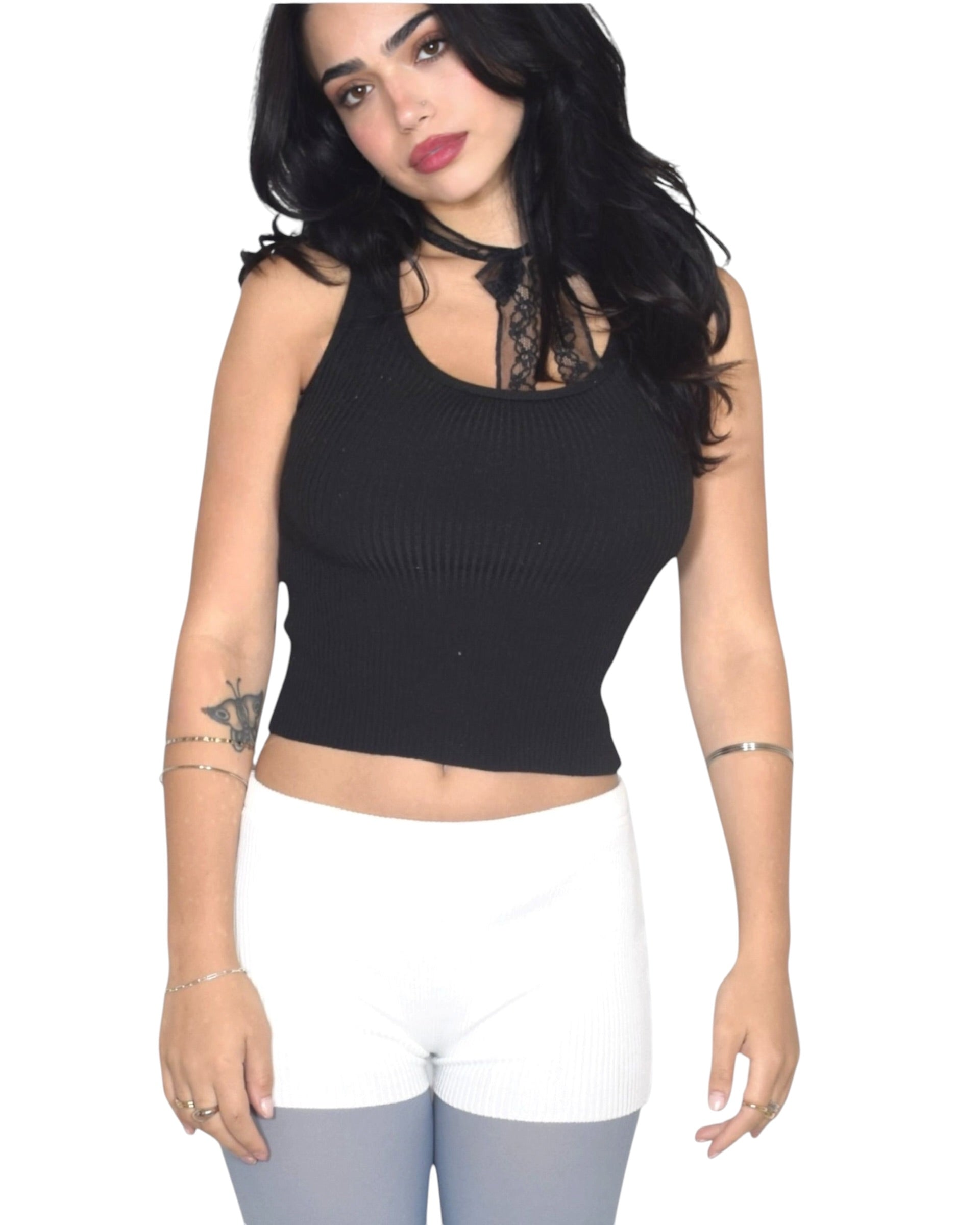 Woman wearing a black sleeveless top with lace details on a white background