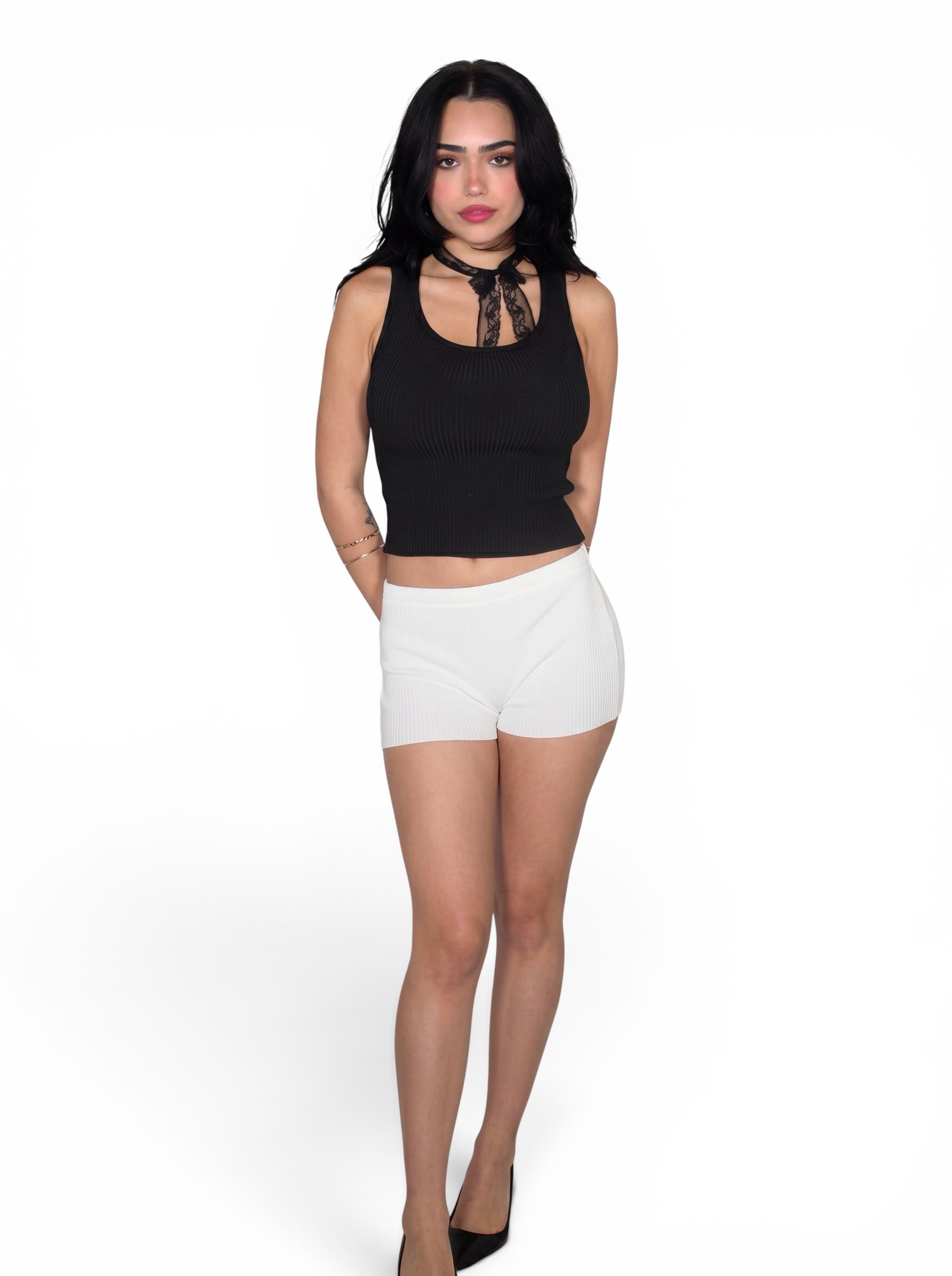 Woman wearing black rib knit scoop neck tank and white hot pant by TKHLA 