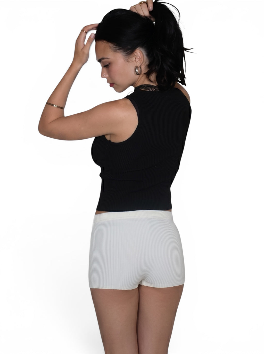 Woman wearing white rib hot pants and black tank by TKHLA 