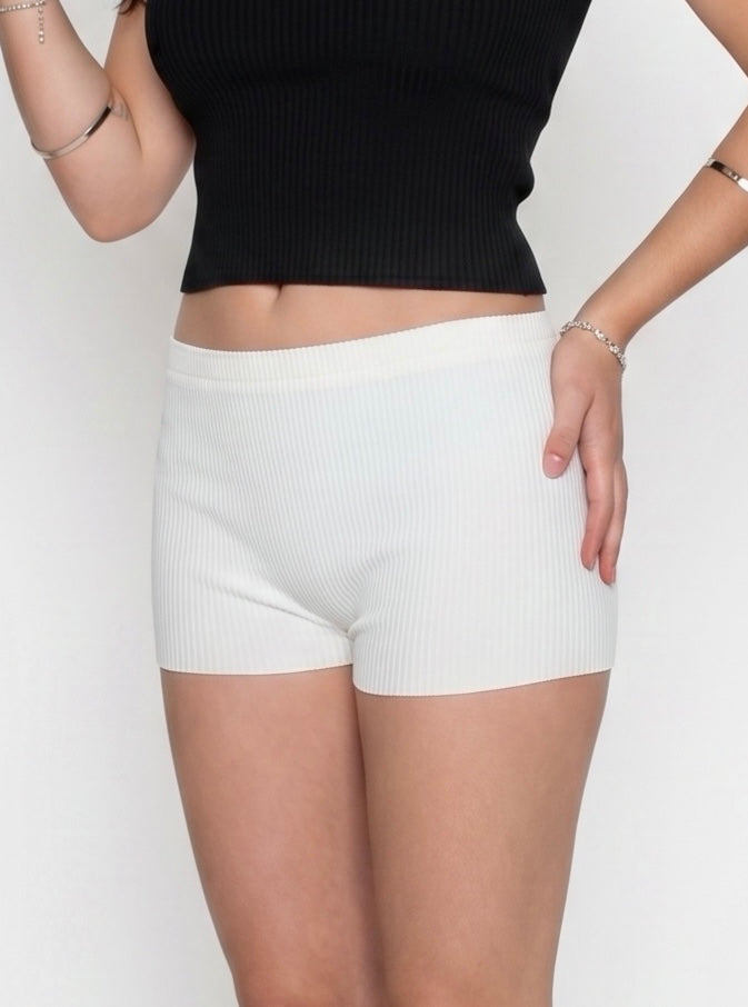 Woman wearing white rib knit hot pants and black tank by TKHLA 