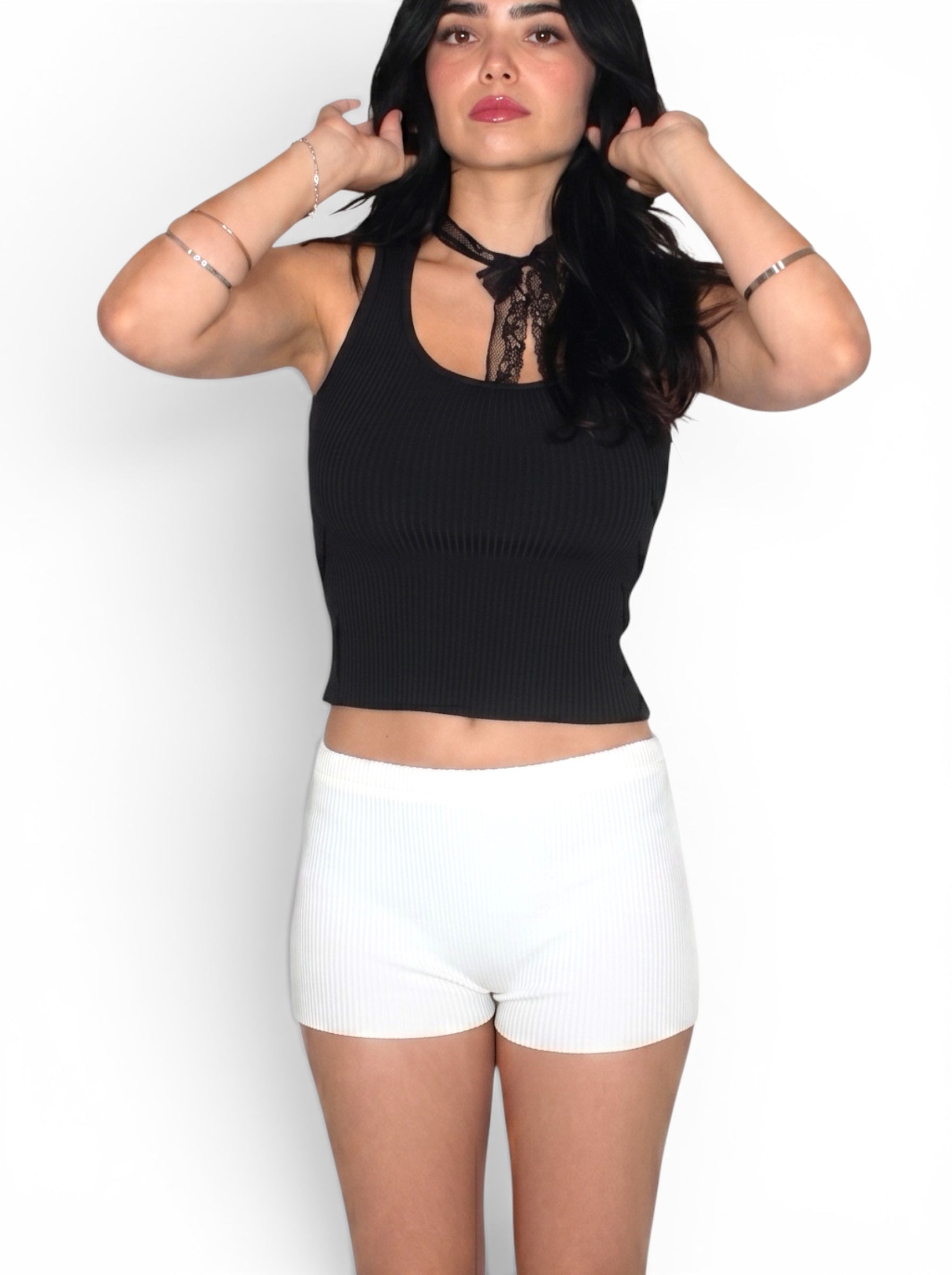 Woman wearing black rib knit scoop neck tank and white hot pants by TKHLA 