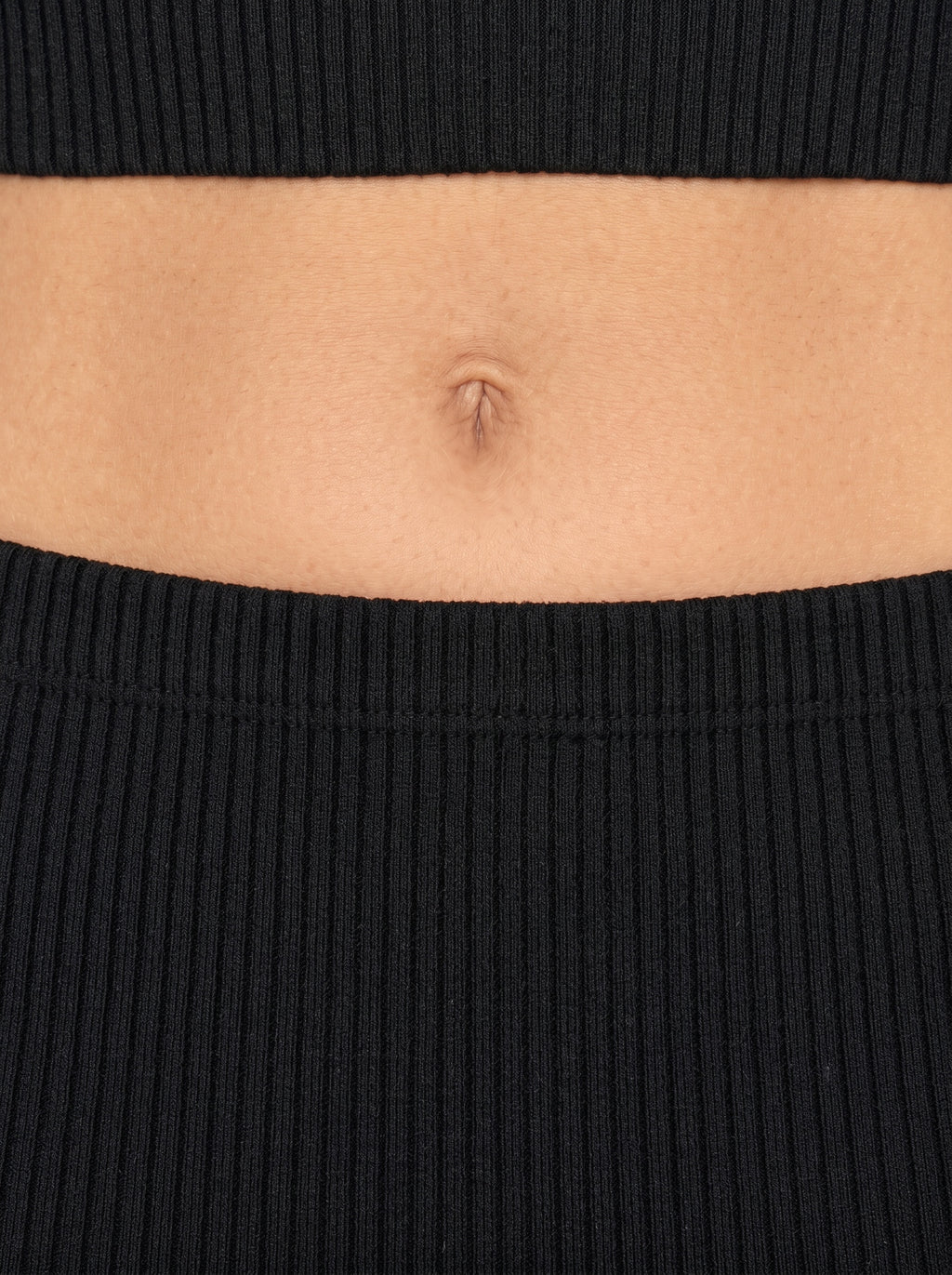 Close up of waist in black rib knit by TKHLA 