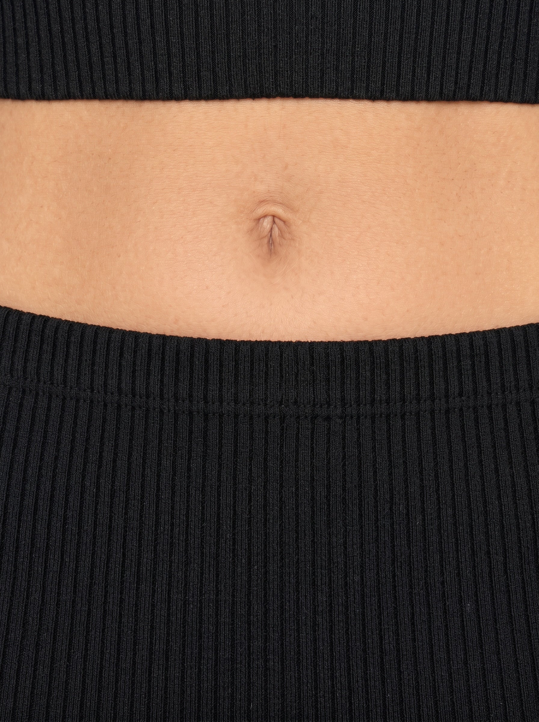 Close up of waist in black rib knit by TKHLA 