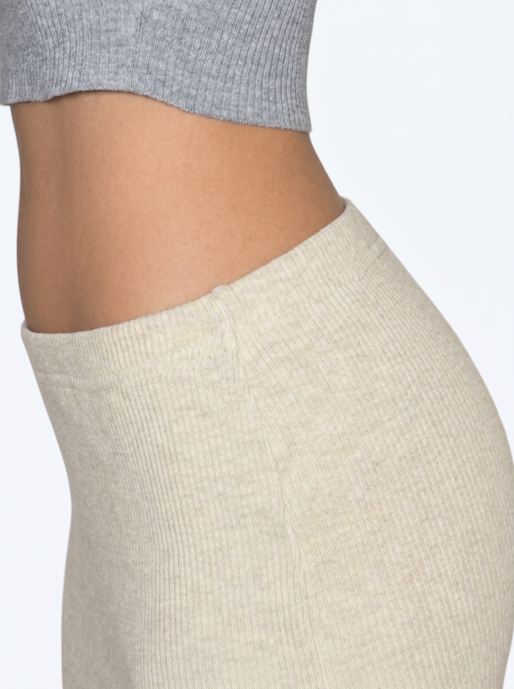 Close up of grey rib knit top and beige pencil skirt by TKHLA 