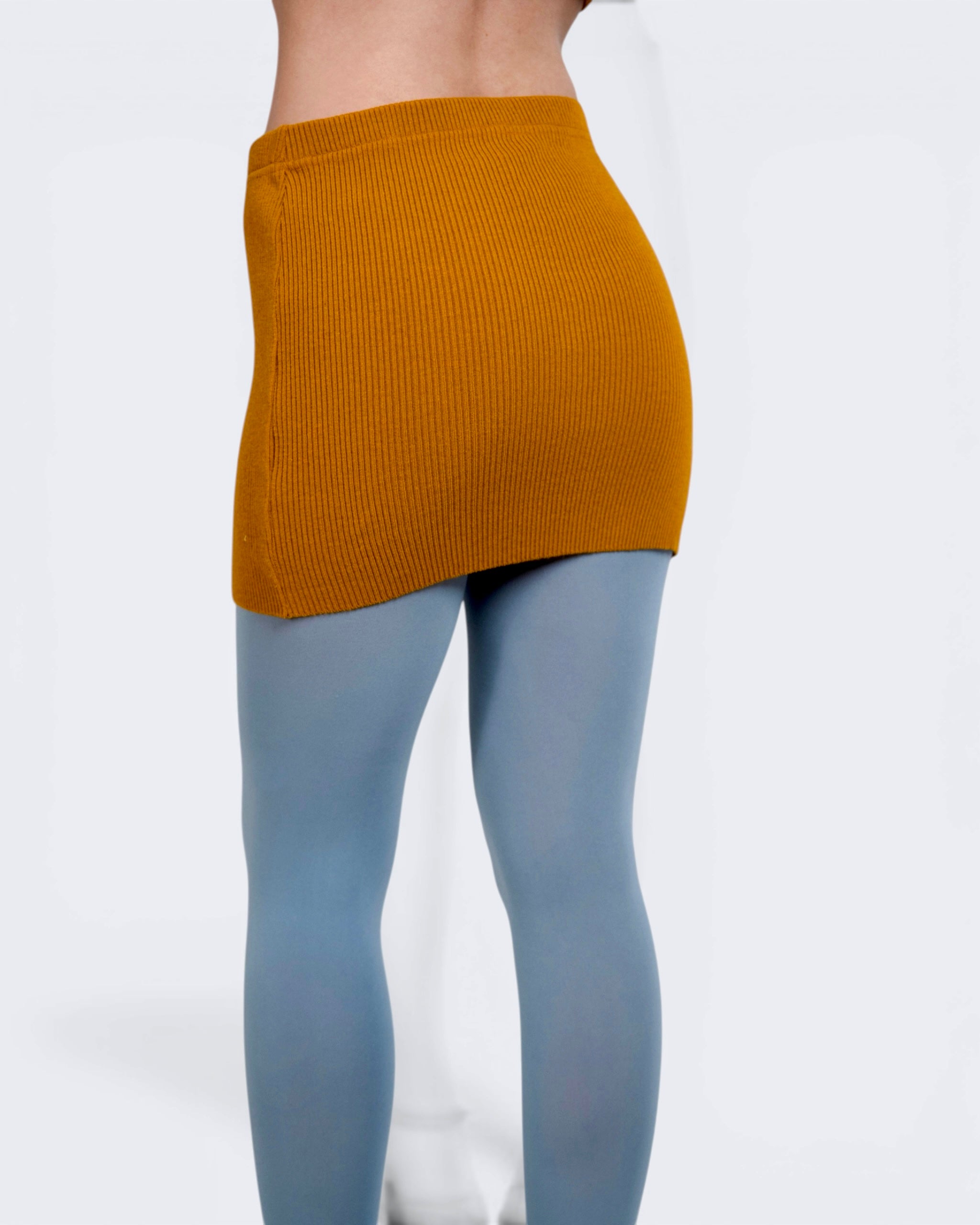 Person wearing mustard rib knit mini skirt by The Knit House LA, with steel tights