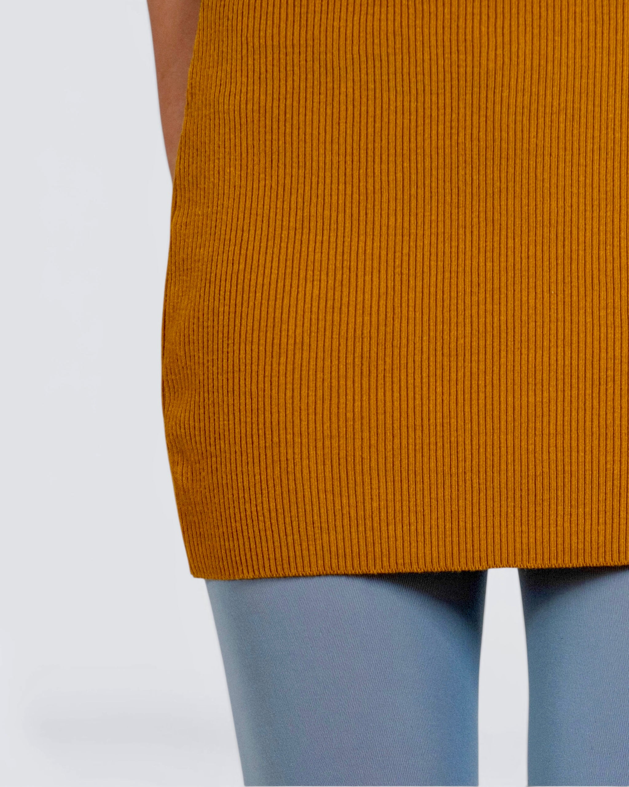 Close up of front of mustard rib knit mini skirt by The Knit House La, with steel tights. 