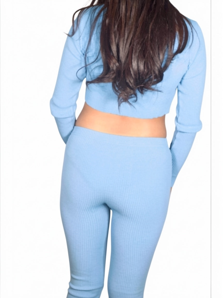 Person wearing a light blue long-sleeve top and leggings set on a white background