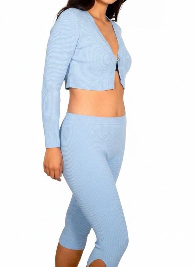 Woman wearing a light blue cropped jacket and leggings on a white background