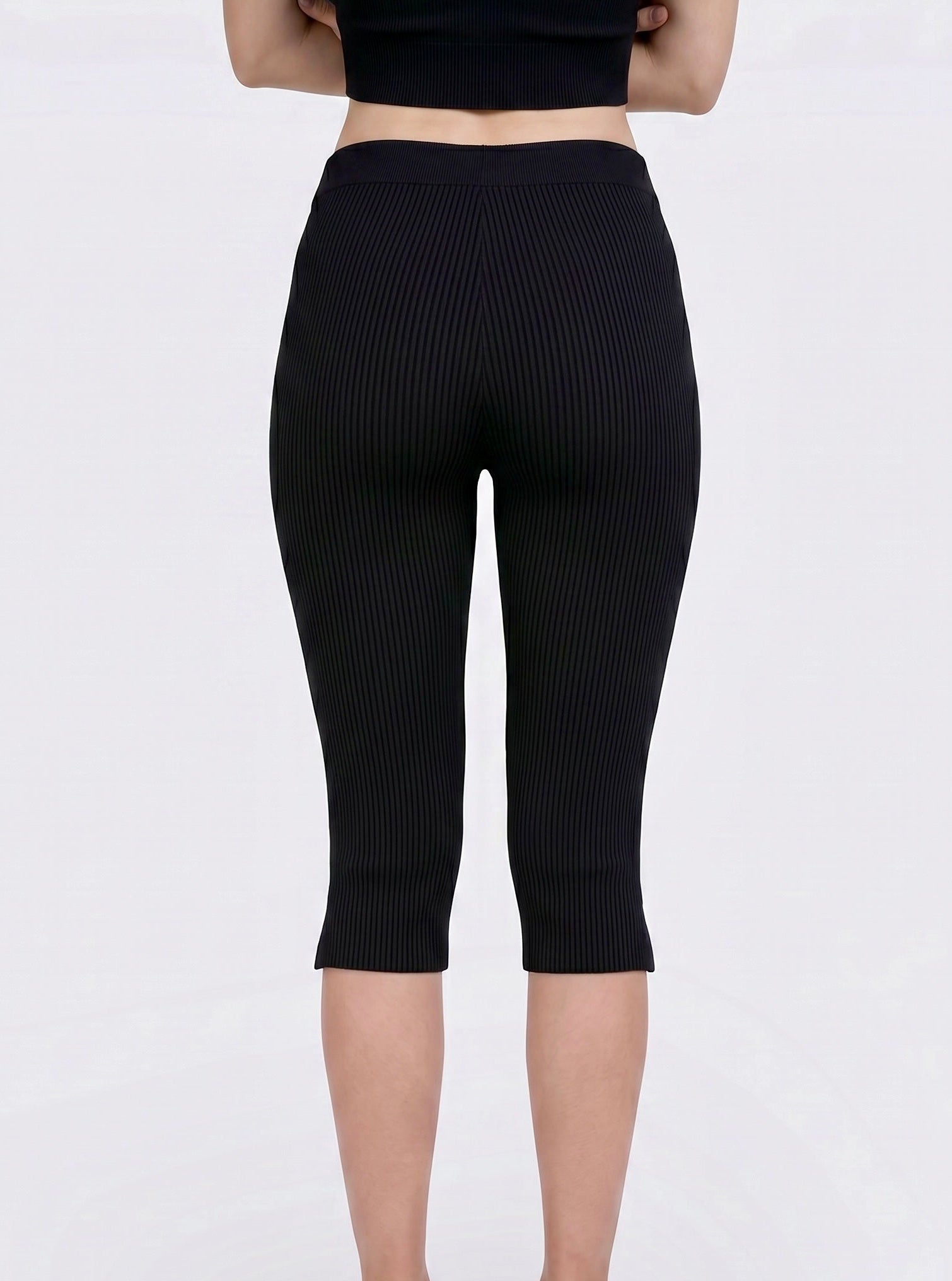 Back view of black rib knit Capri with side slits by TKHLA 