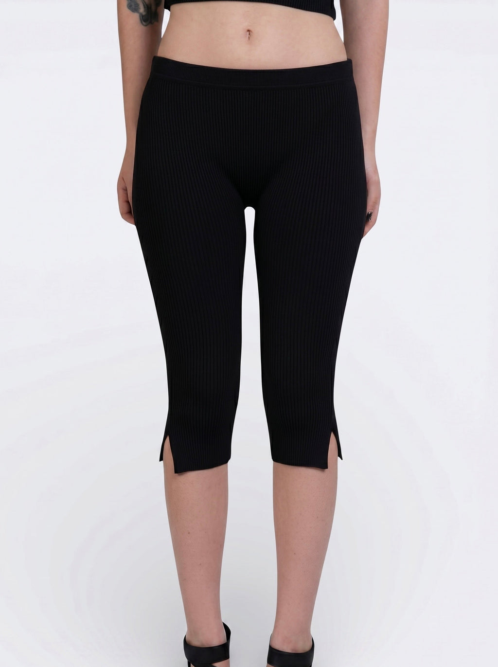 Front view of black rib knit Capri with side slit by TKHLA 