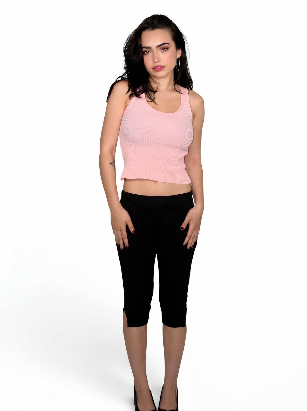 Woman wearing pink rib knit scoop neck tank and black capris with slit by TKHLA