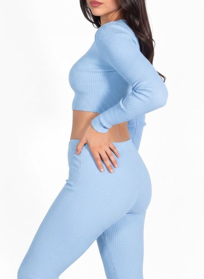 Woman wearing a light blue ribbed outfit on a white background