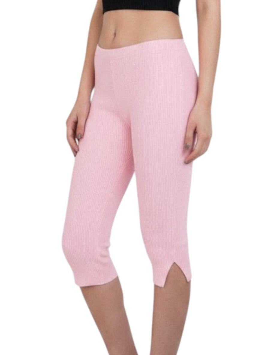 Person wearing pink capri leggings on a white background