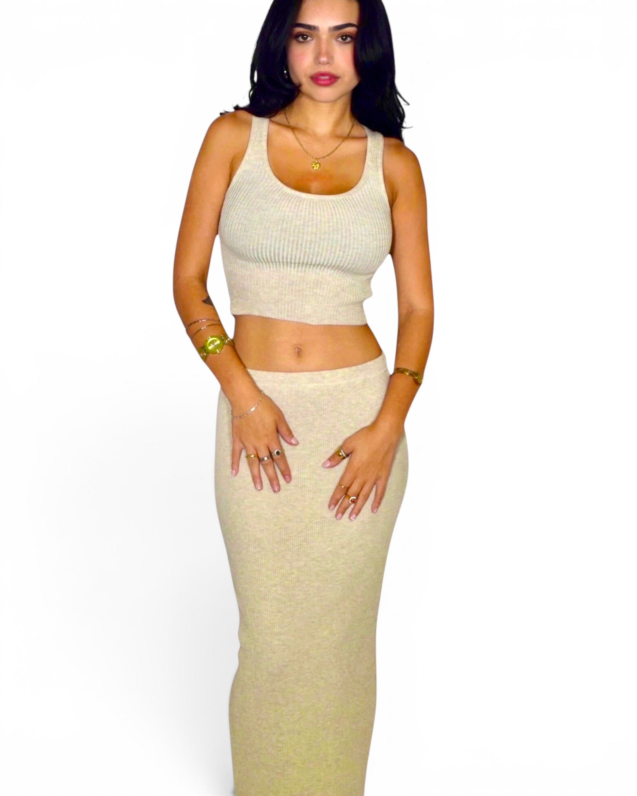Woman wearing beige set of crop tank and long straight skirt. 