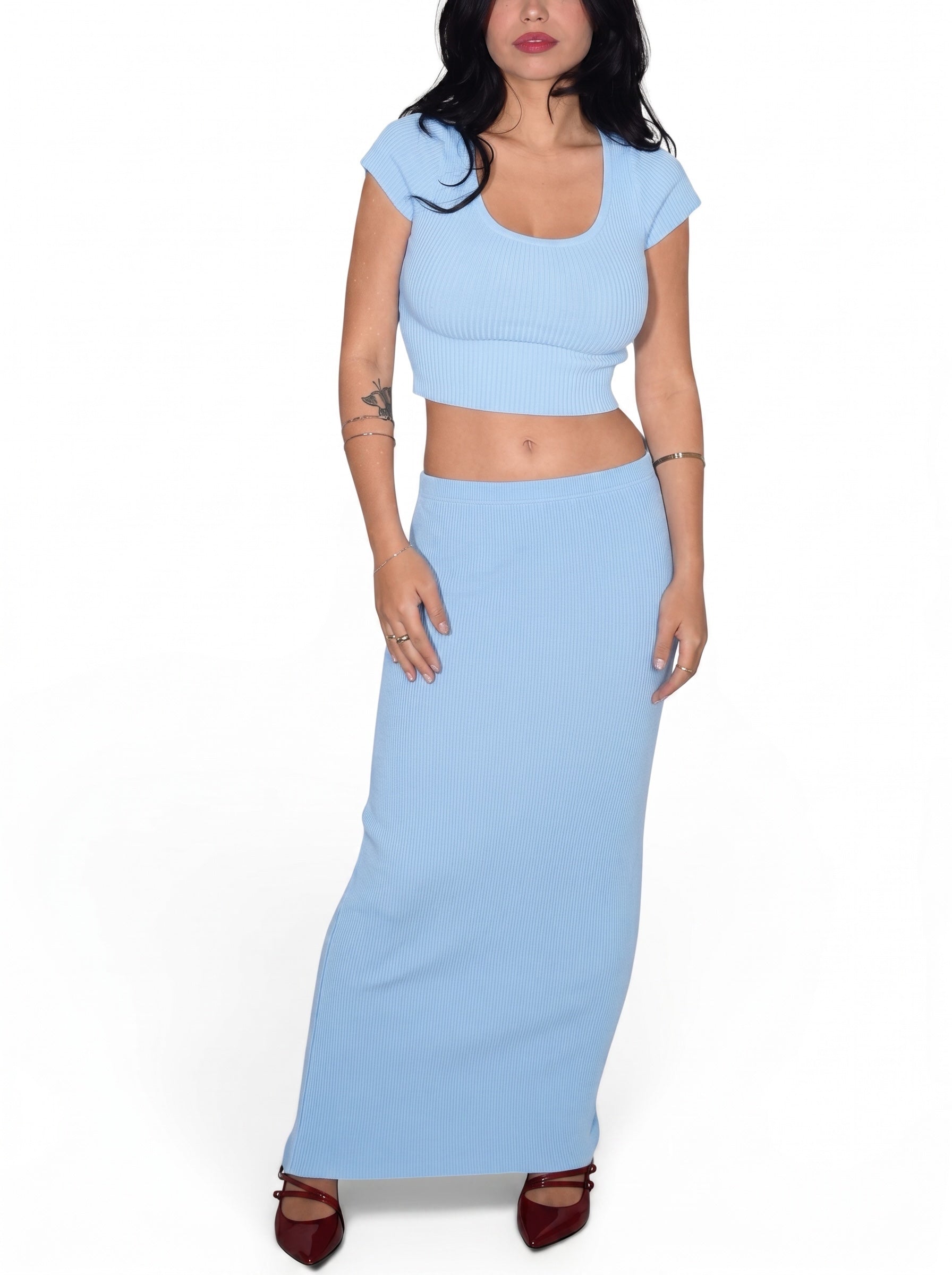 Woman wearing a light blue two-piece outfit on a white background