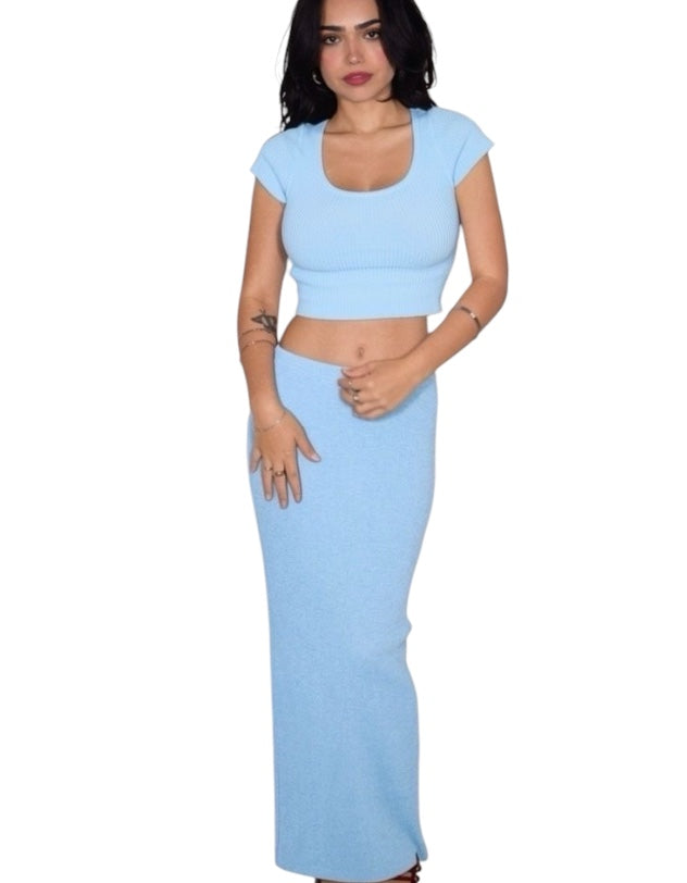 Woman wearing a light blue two-piece outfit on a white background
