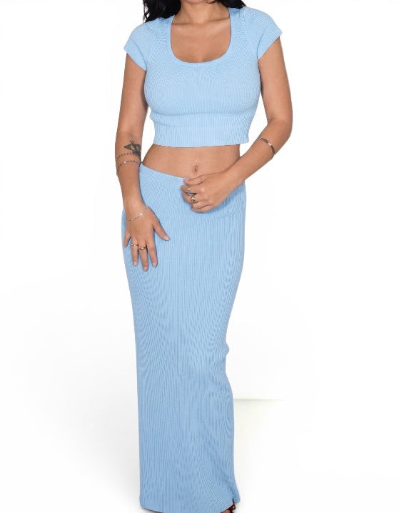 Woman wearing a light blue two-piece outfit on a white background