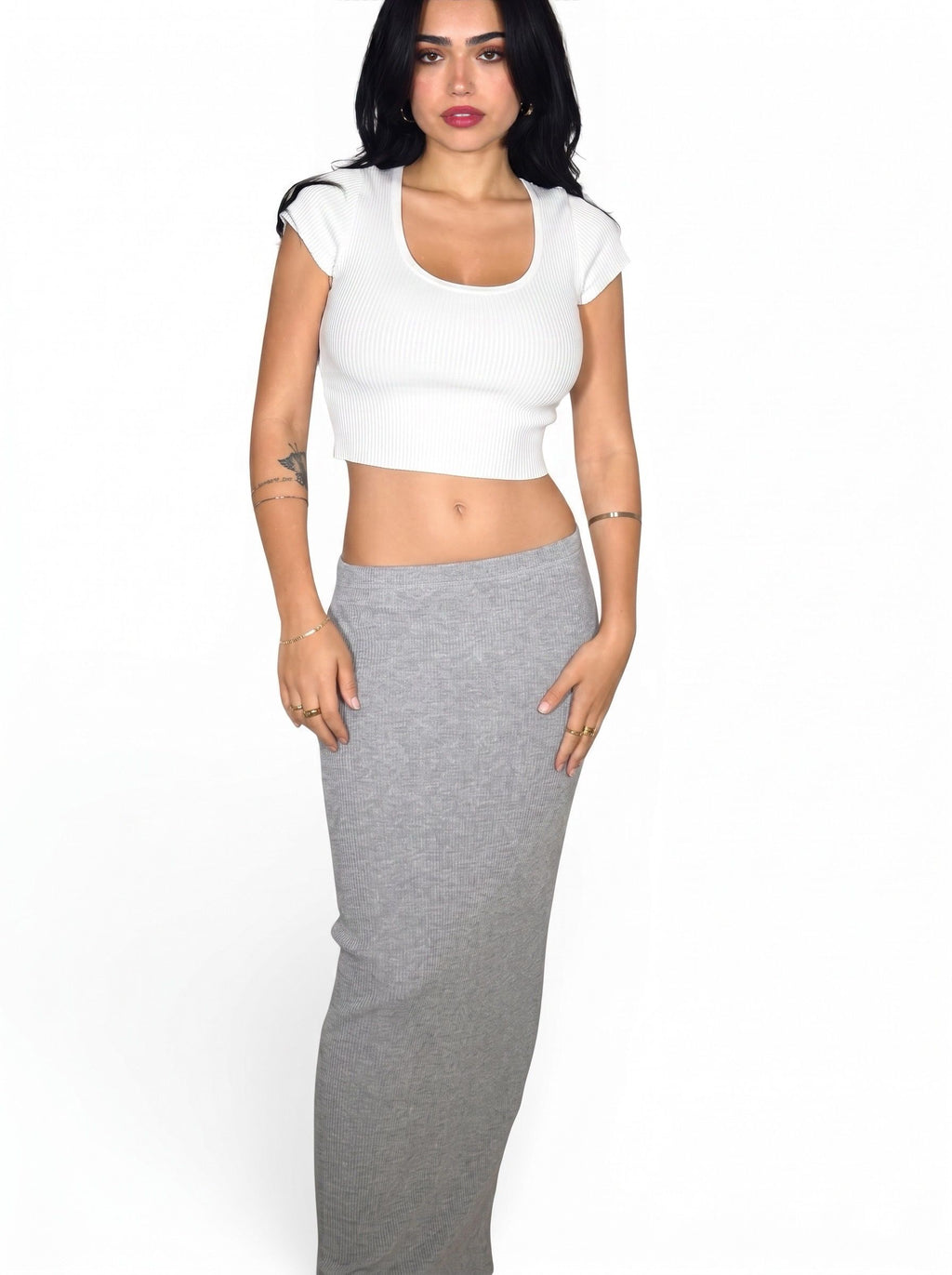 Woman wearing rib knit white crop top and grey long straight skirt by TKHLA 