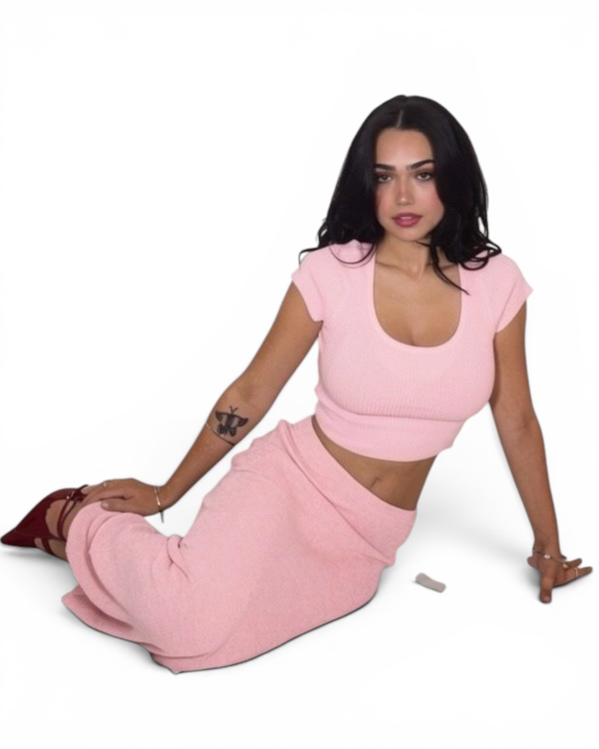 Woman wearing a pink outfit sitting on a white background
