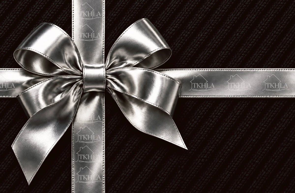 A metallic silver satin ribbon tied into a large bow, wrapped around a dark textured fabric gift box. The ribbon features a repeating embossed logo of 'JTKHILA'.