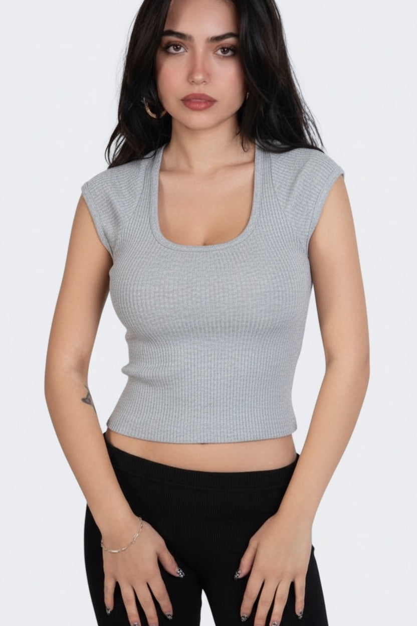 Woman wearing a gray sleeveless top against a white background