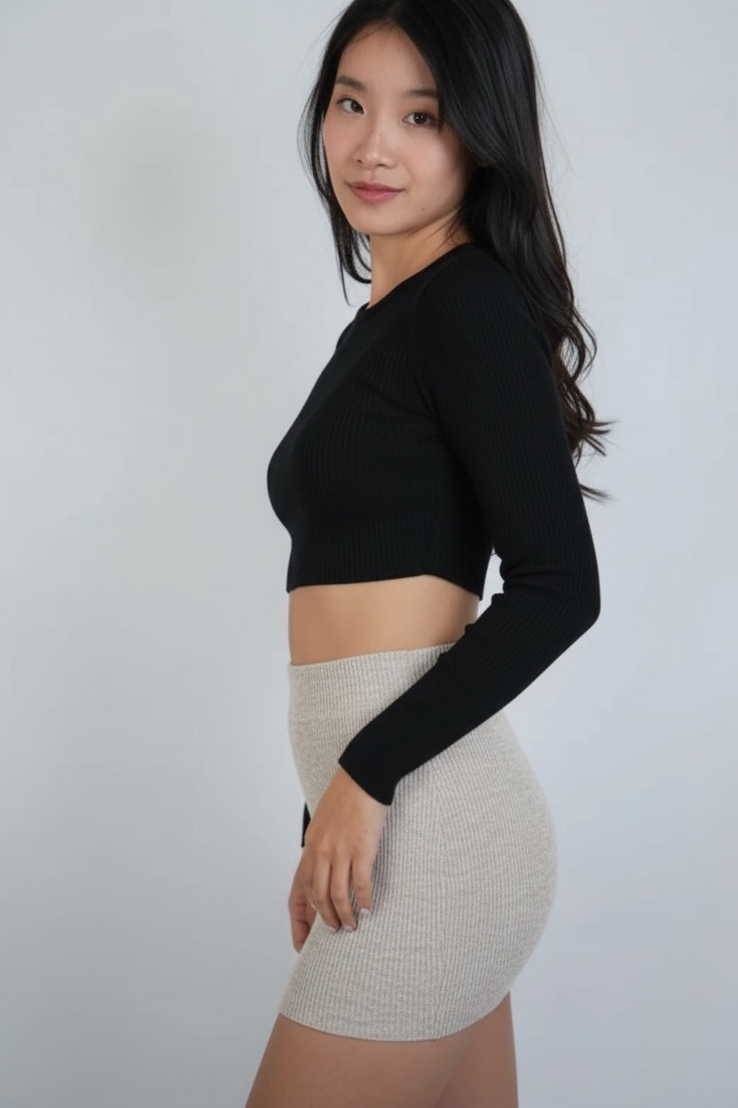Woman wearing a black long-sleeve top and Drift beige micro mini skirt by The Knit House LA against a white background