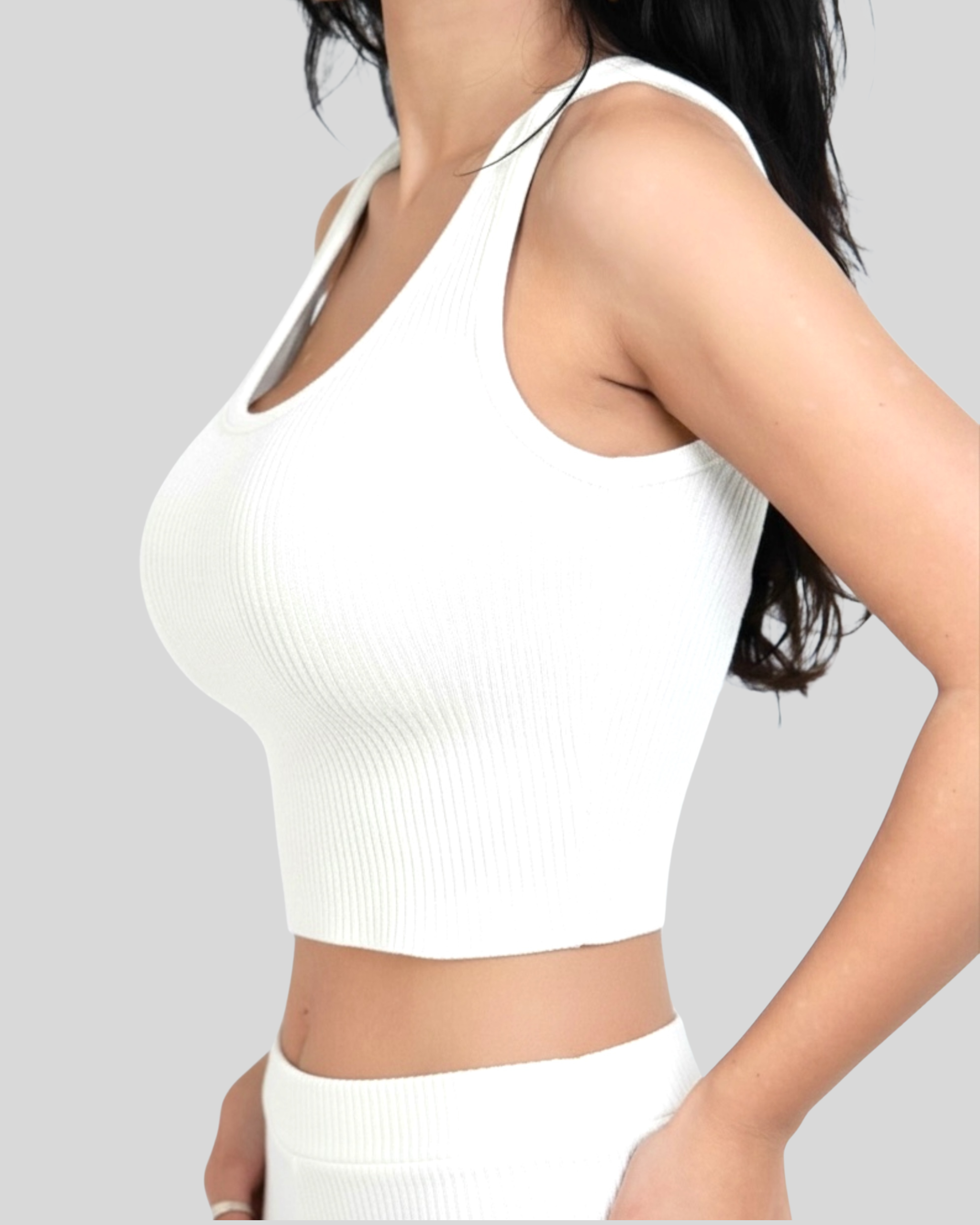 Person wearing a white scoop-neck crop tank on a plain background