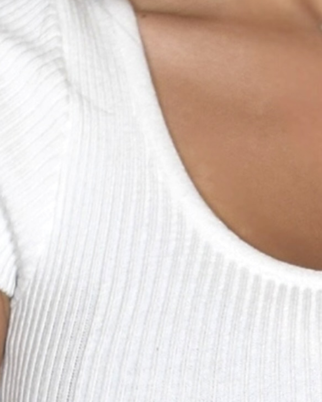 Close-up of a white ribbed knit top with a scoop neckline.