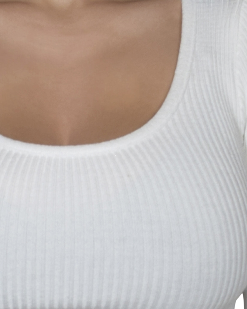 Close-up of a person wearing a white ribbed scoop-neck top.
