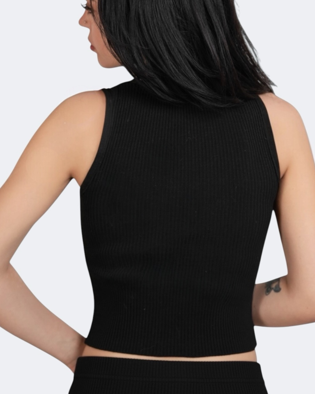 Black ribbed tank top worn by a person on a light gray background