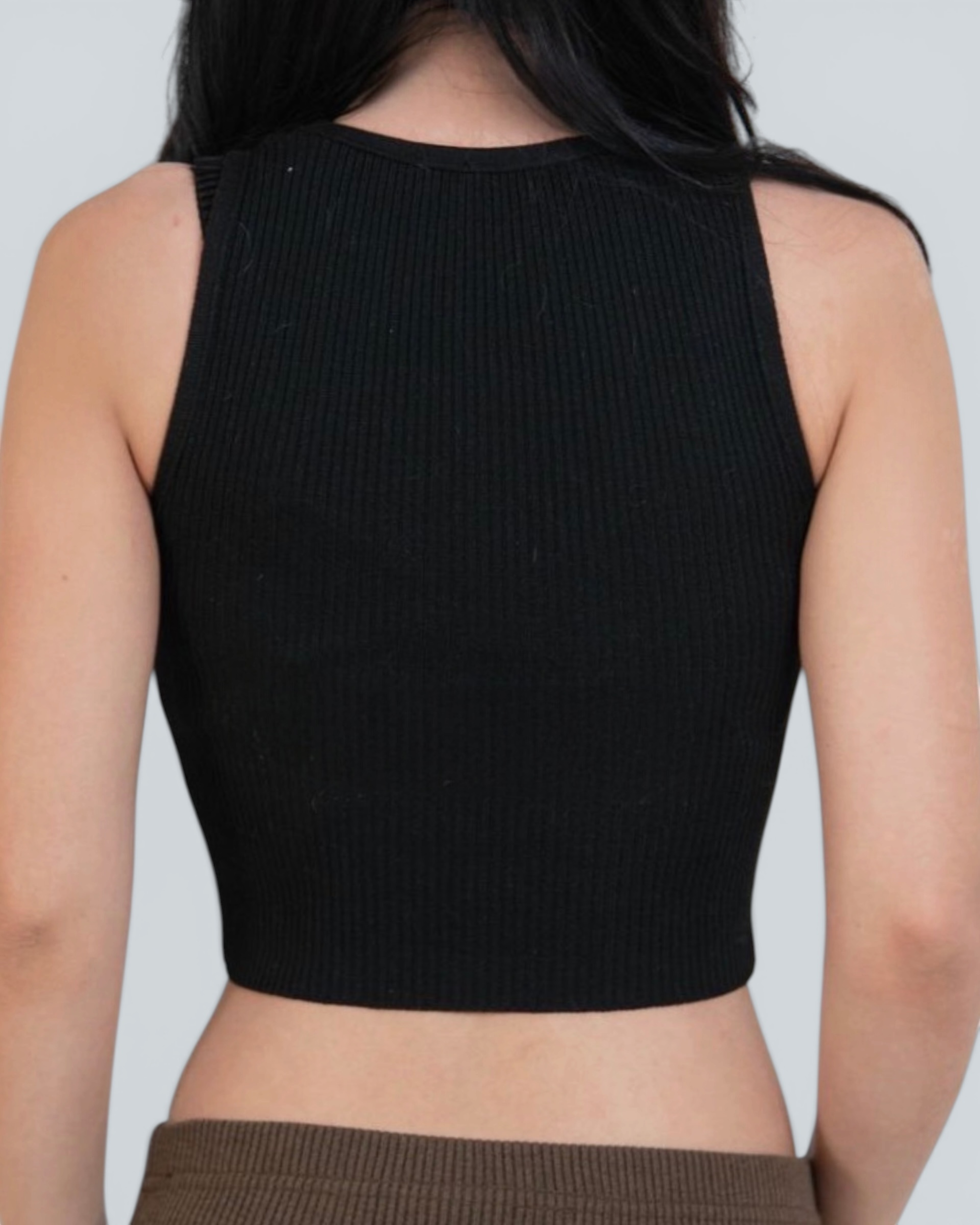 Black ribbed tank top worn by a person on a plain background