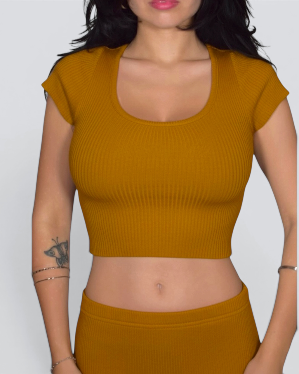 Mustard yellow ribbed crop top worn by a person on a plain background