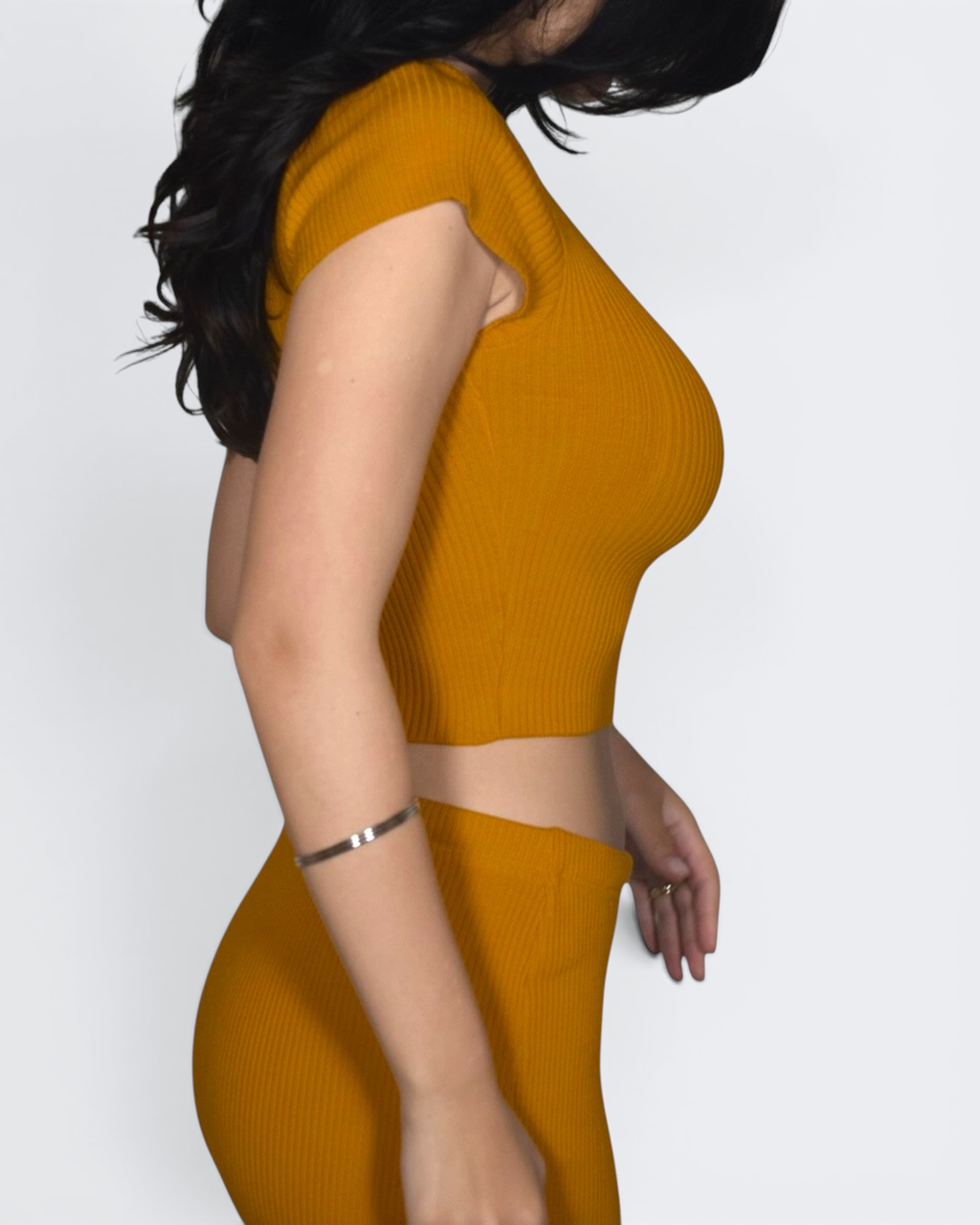 Person wearing a mustard yellow outfit against a white background
