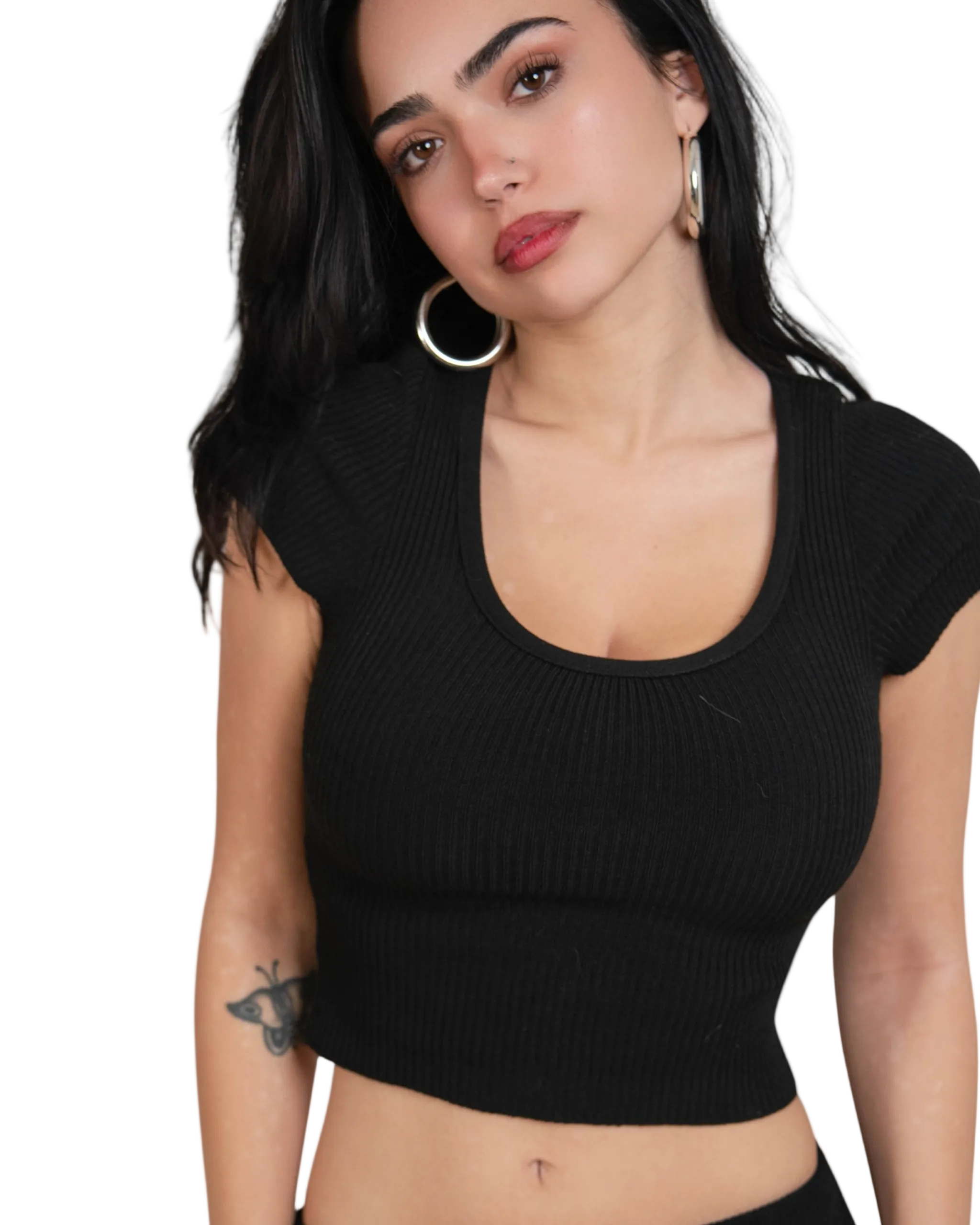 Woman wearing a black ribbed crop top against a white background