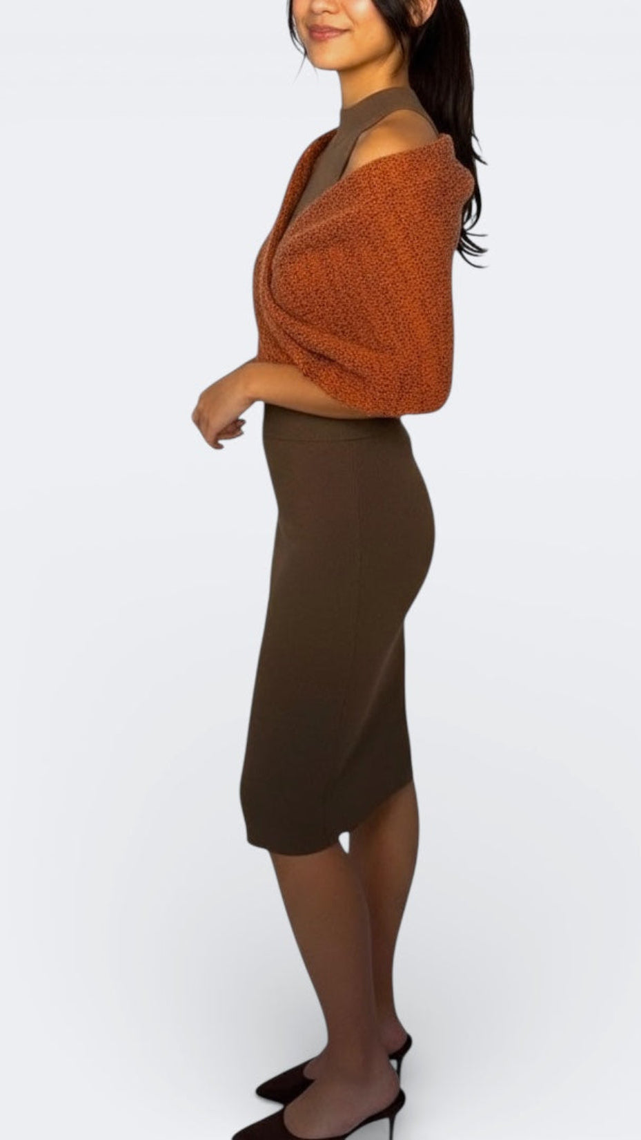 Woman wearing an orange and rust ember glow scarf by The Knit House LA  and skirt on a white background