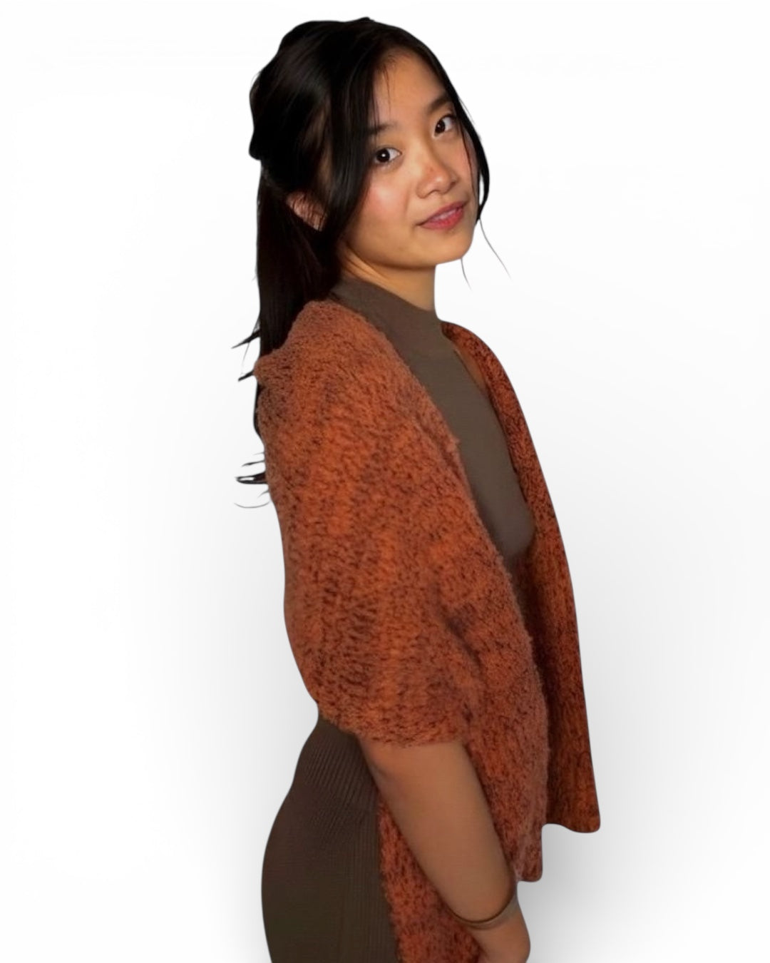 Woman wearing an orange rust ember glow scarf by The knit House LA over a brown dress on a white background