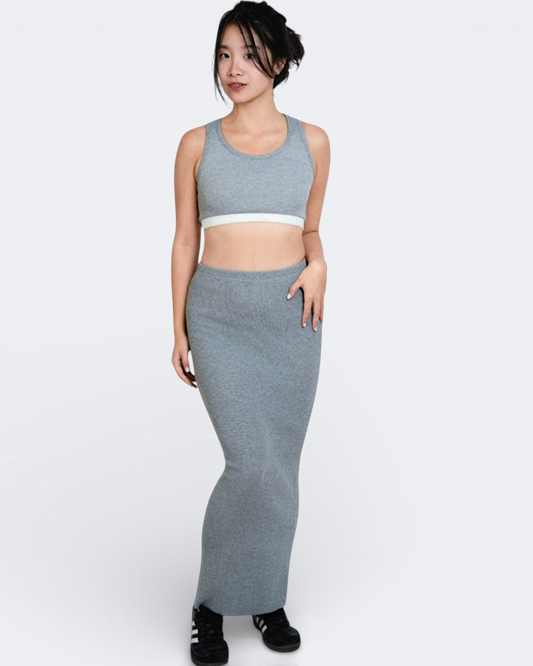 Woman wearing a gray athletic outfit on a white background