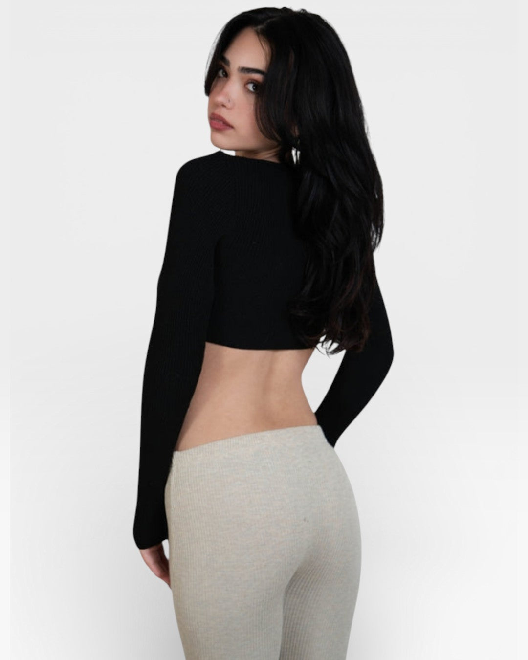 Woman wearing a fitted rib Ink black long-sleeve crop top by the Knit House LA. on a white background