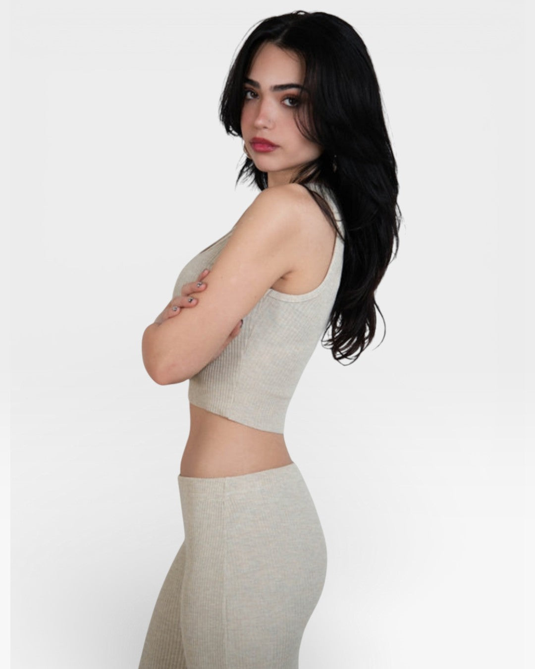 Woman wearing a Drift beige rib knit tank top with scoop neckline and pants by The Knit House LA on a white background