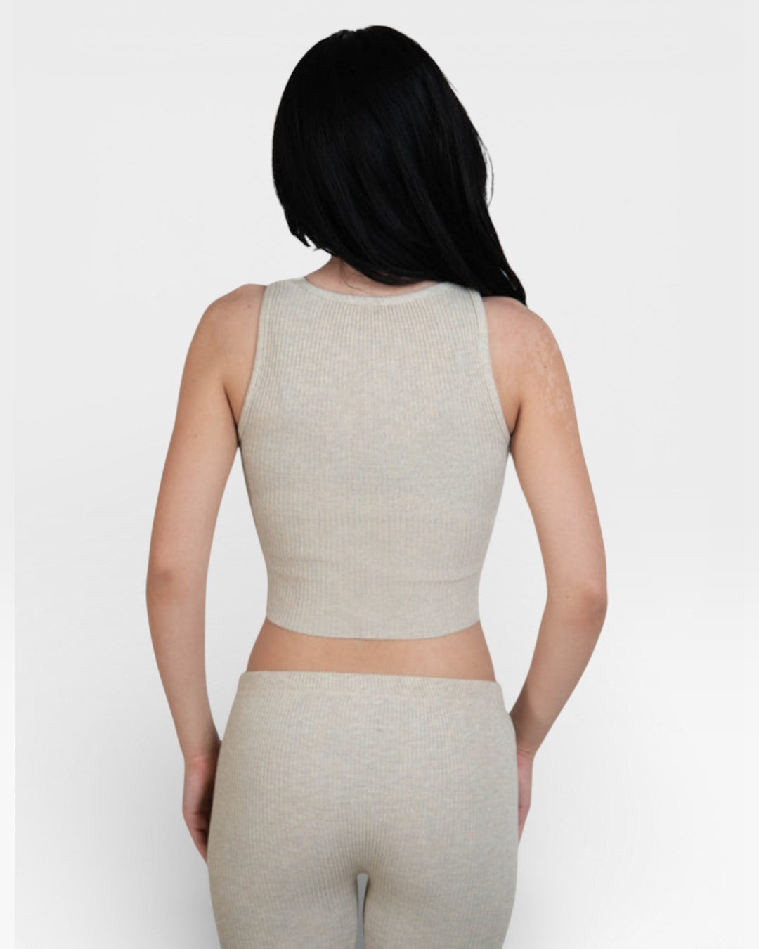 Person wearing a Drift beige tank top and leggings by The Knit House LA on a white background