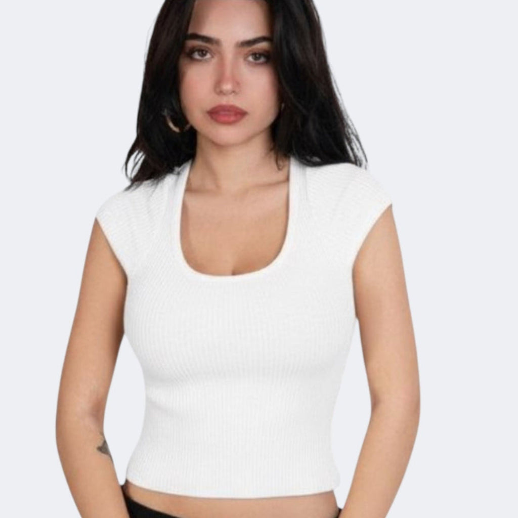 Woman wearing a porcelain white short sleeve top with scoop neckline by The Knit House LA against a plain background