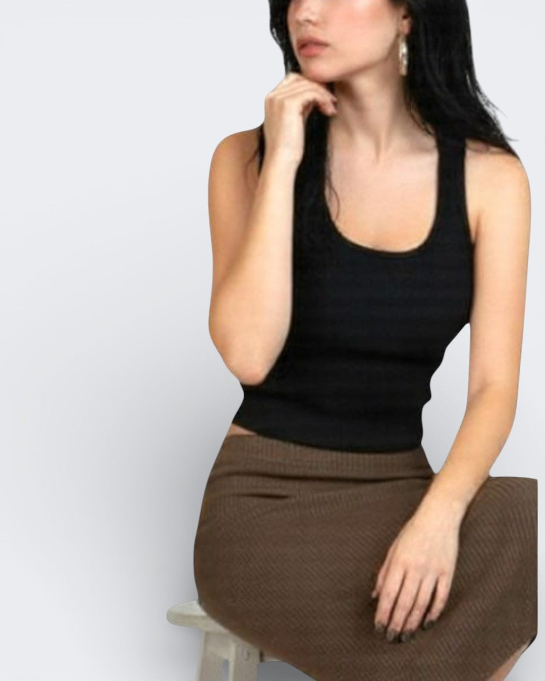 Woman wearing a fitted rib knit tank top with scoop neckline in Ink black and brown skirt by The Knit House LA on a light gray background