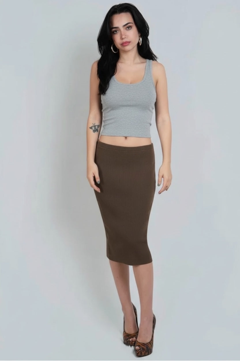 Woman wearing a gray tank top and brown pencil skirt on a plain background