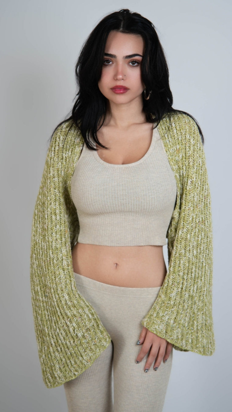 woman wearing a long sleeve dill green knit shrug over drift beige outfit by The Knit House La.